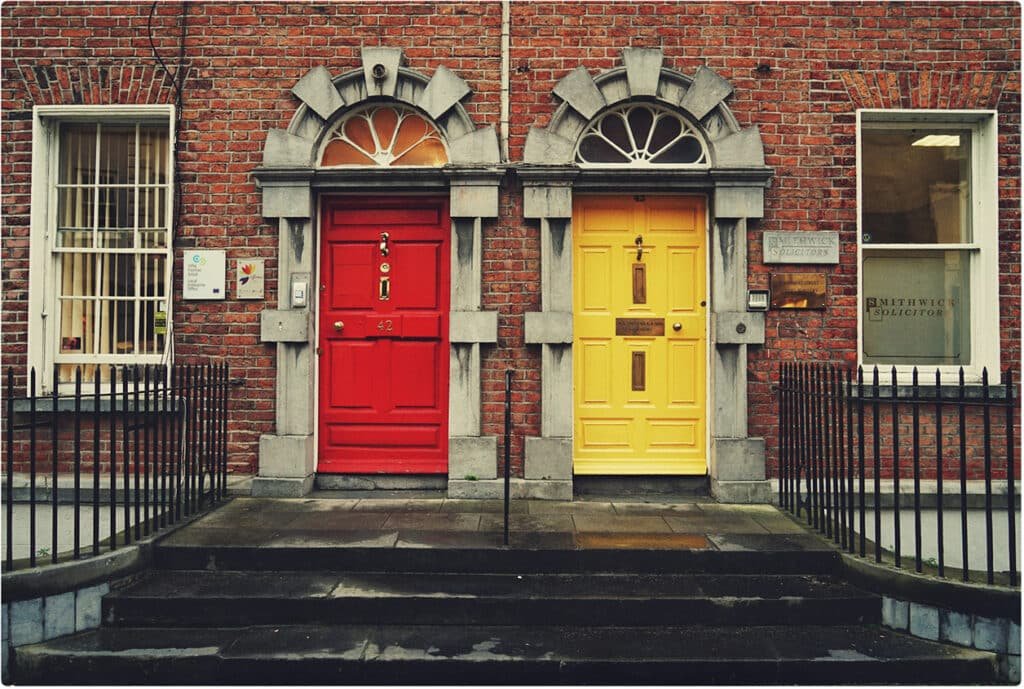 Red door and yellow door side by side on brick building, symbolizing choices in midlife transition.