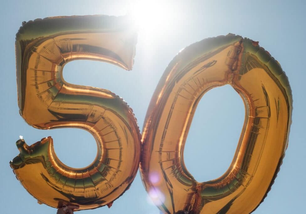 A photograph of balloon numbers against a sunlit sky. The numbers are 5- and 0- and are used to commemorate a fiftieth birthday.